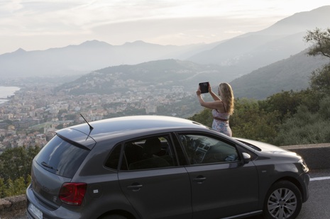 Tourist taking picture in front of a rental car.jpg